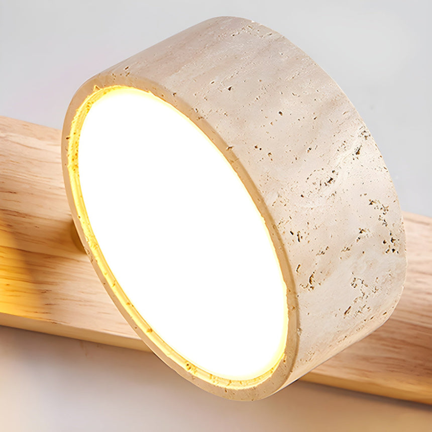 Close view of one travertine disc lit from within, the stone ring glowing warm