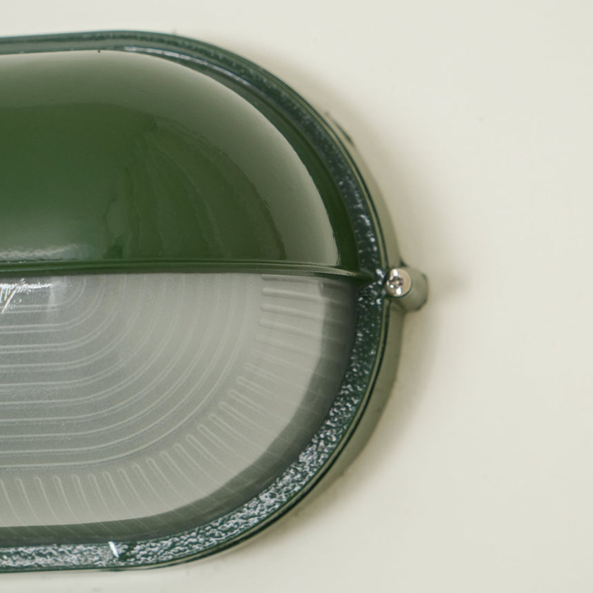 Metal frame wall sconce with glass shade close-up