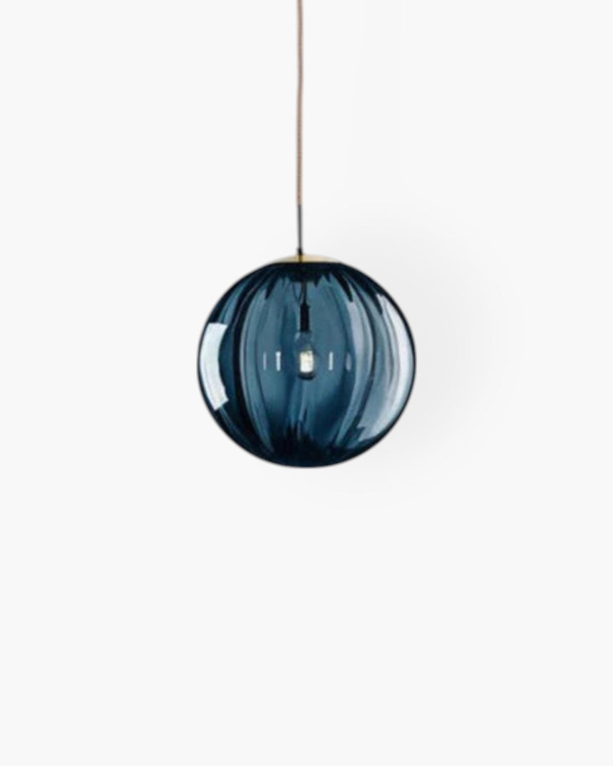 Amber glass pendant light installed above dining table - OpalDwell