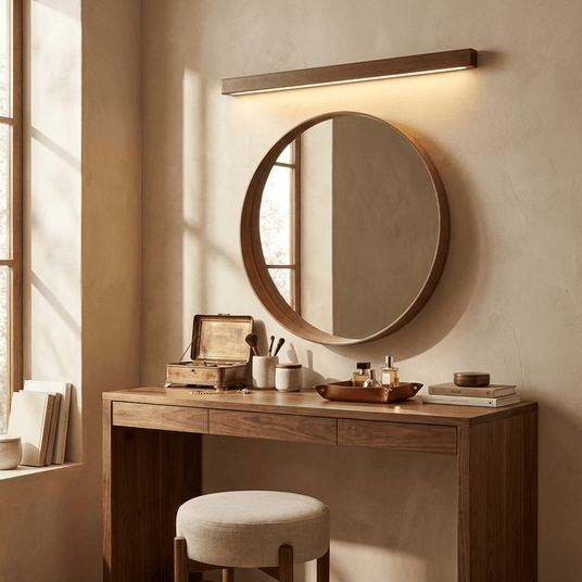 Wood bar lit above a round mirror on a wood dressing table with a stool and pots