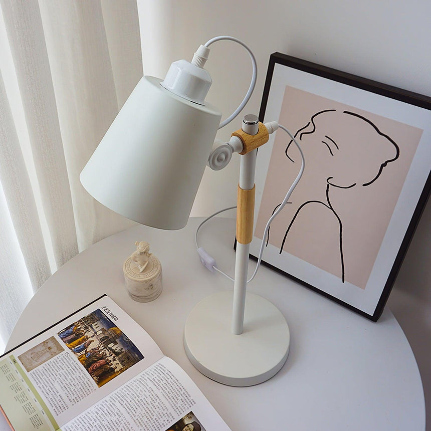 Adjustable desk lamp with the head tilted back beside a framed print