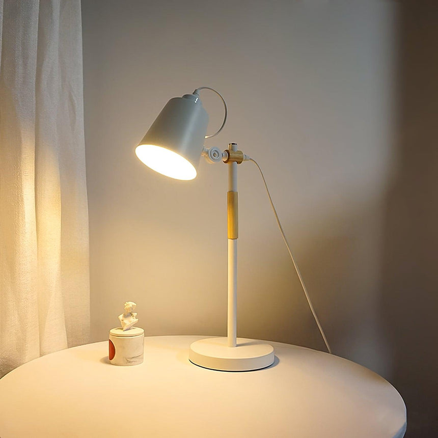 Adjustable desk lamp with the head turned down over a pale table