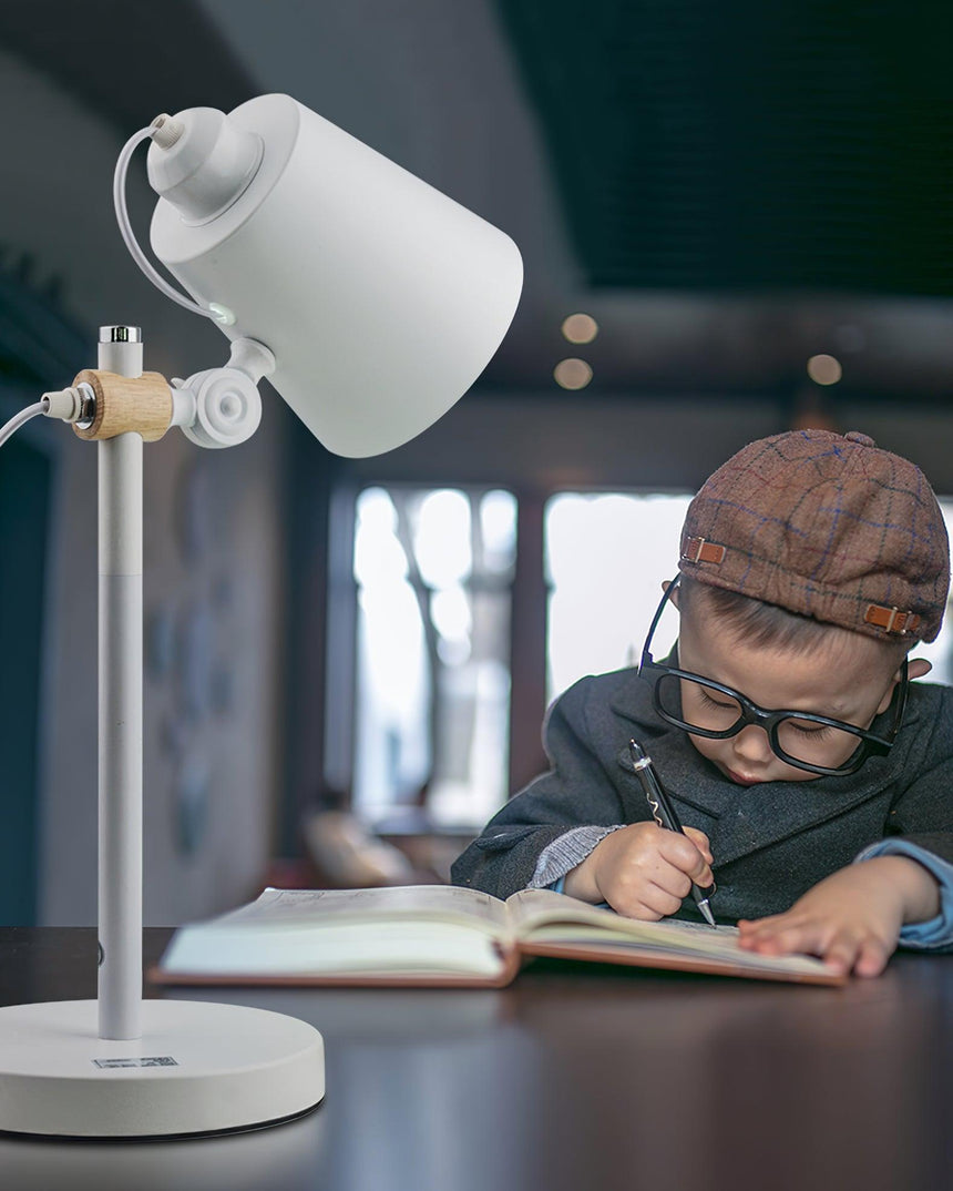 Adjustable desk lamp lit over a child writing in a notebook
