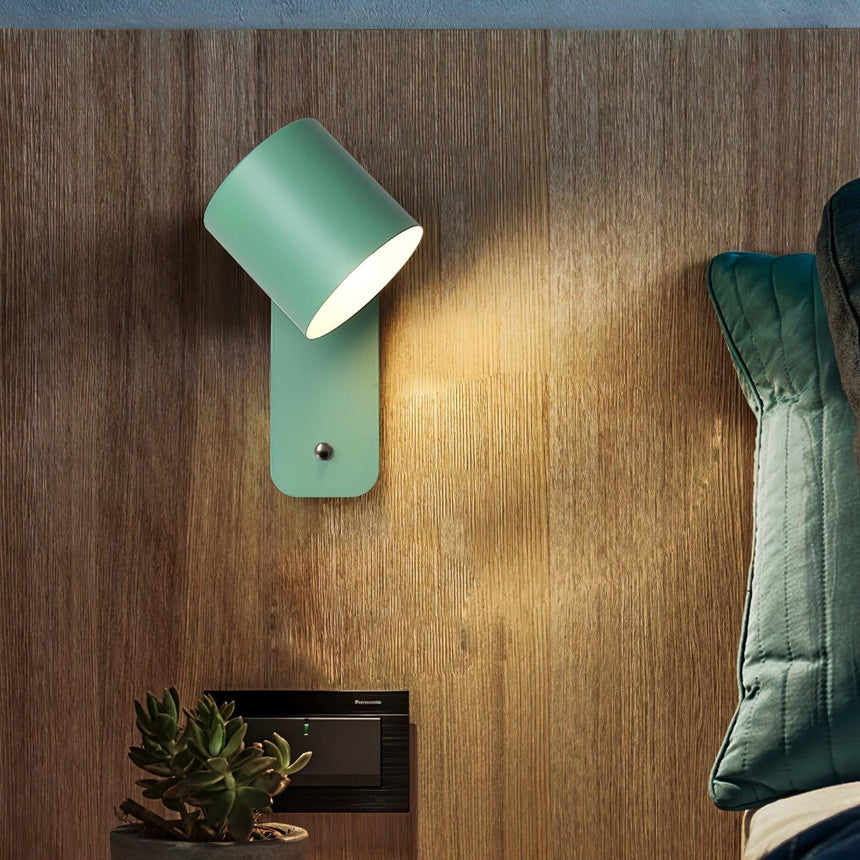 The green finish lit against a timber paneled wall above a green quilted bed