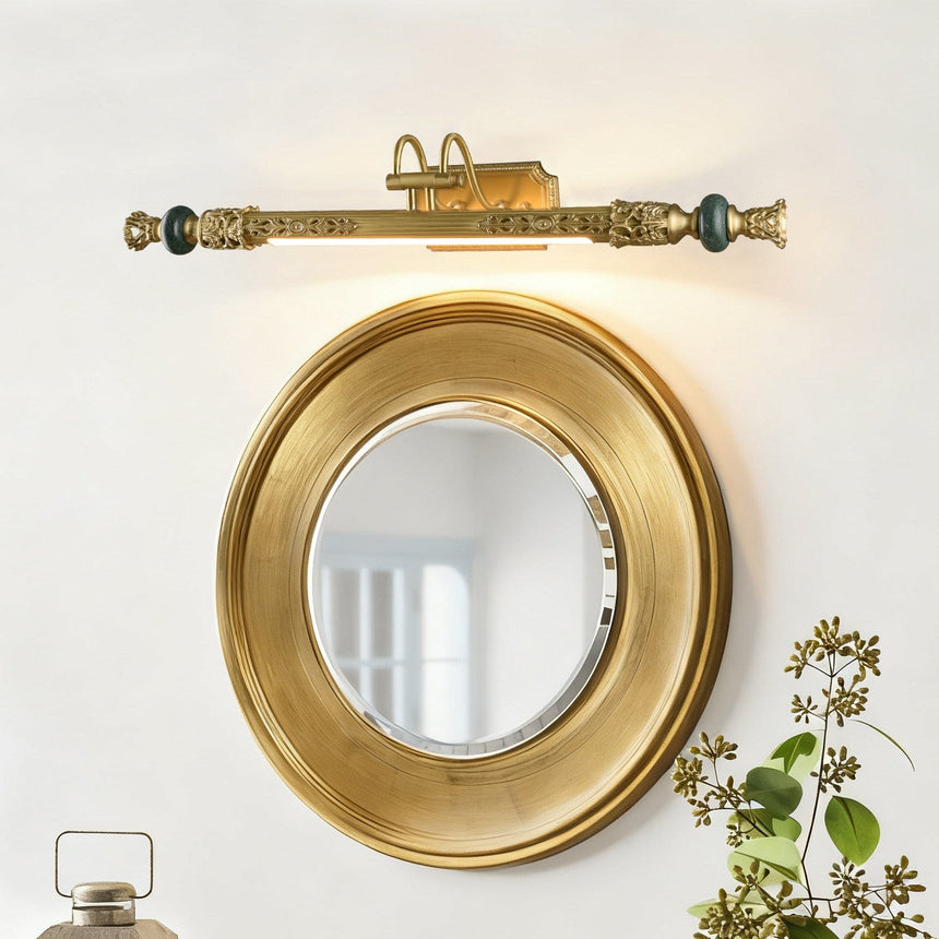 Ornate brass bar above a gilt round mirror with trailing foliage at its side