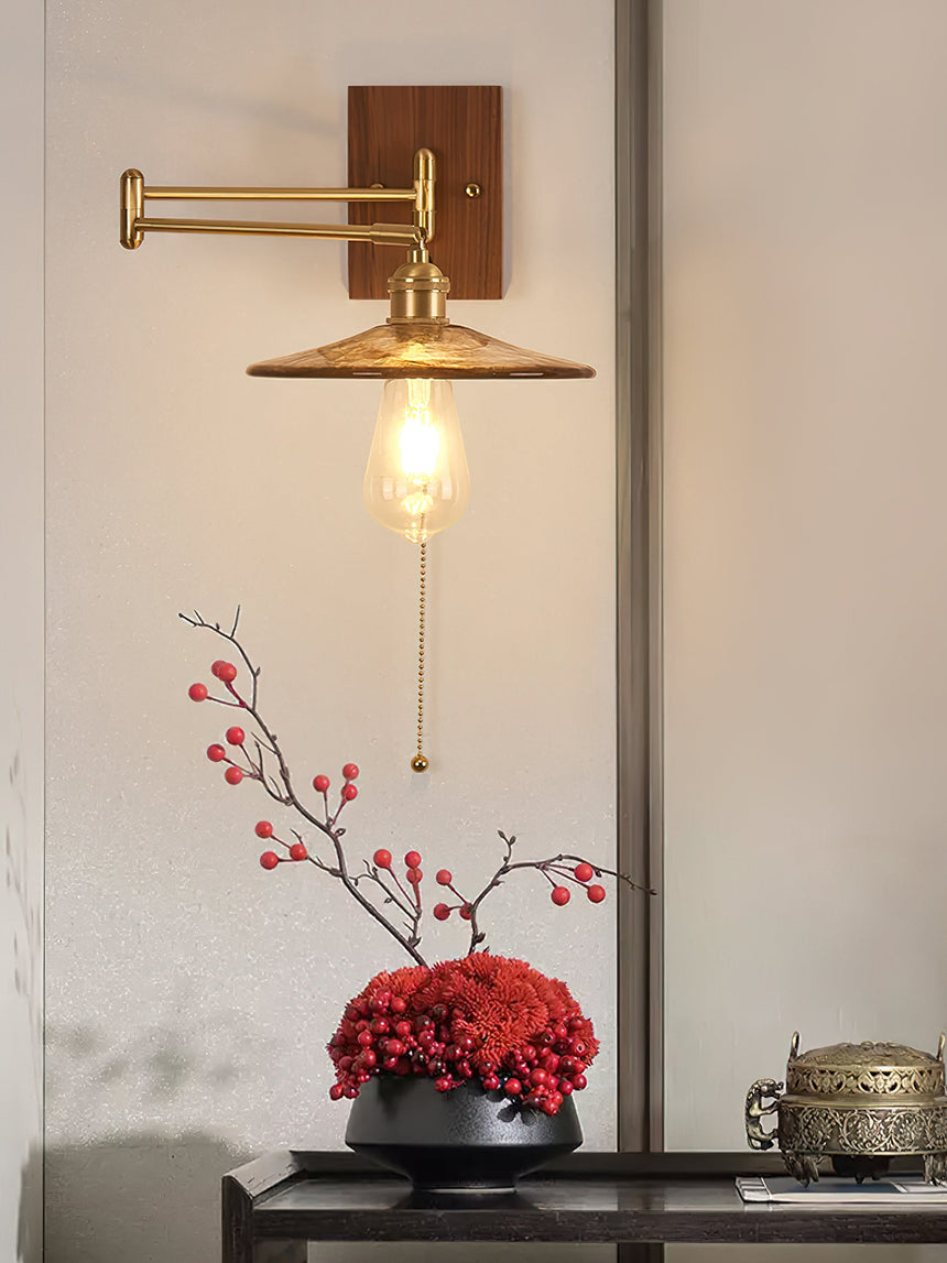 Close view of a lit clear glass disc shade and its brass shade holder
