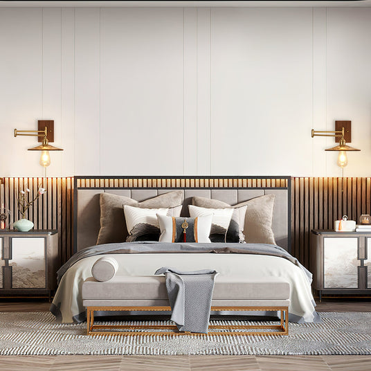 A pair of brass and walnut sconces lit above a slatted wood headboard