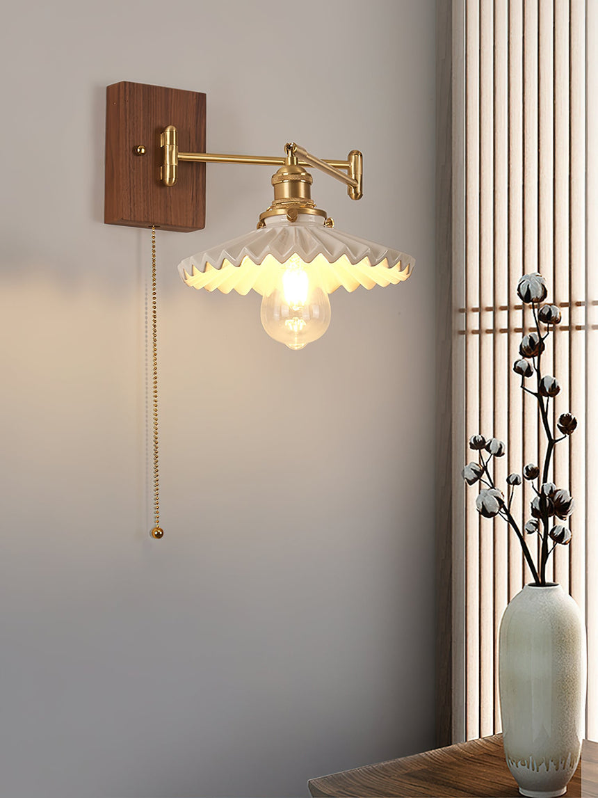 Ribbed cone shade lit with the pull chain hanging from the shade holder