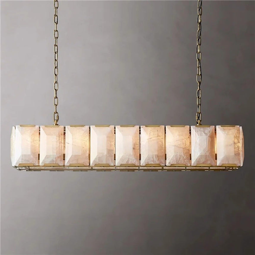 A lit stone cage in a brass frame seen against a gray wall