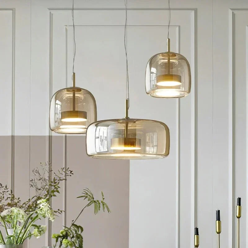 Three amber glass bell pendants hung at different heights
