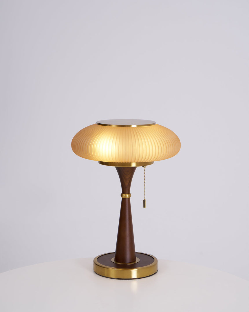 Amber glass cap on a walnut stem, lit on a plain ground