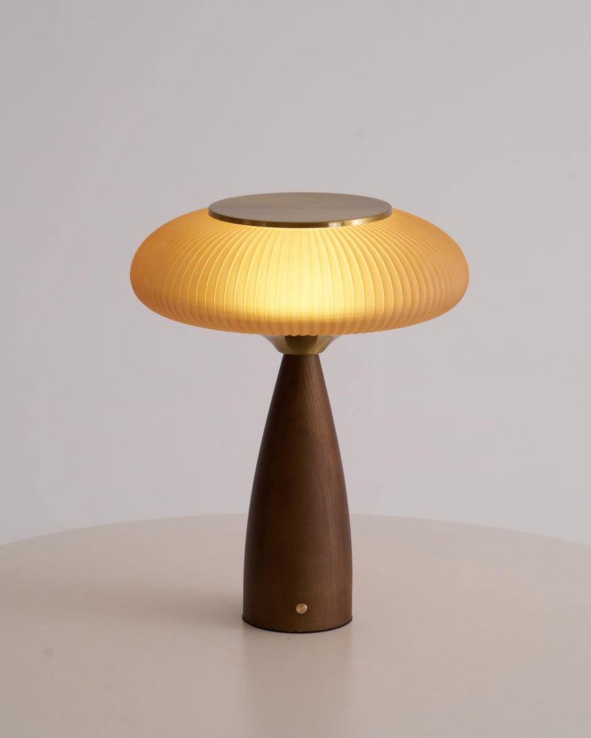 Amber glass table lamp seen from the front against a plain ground