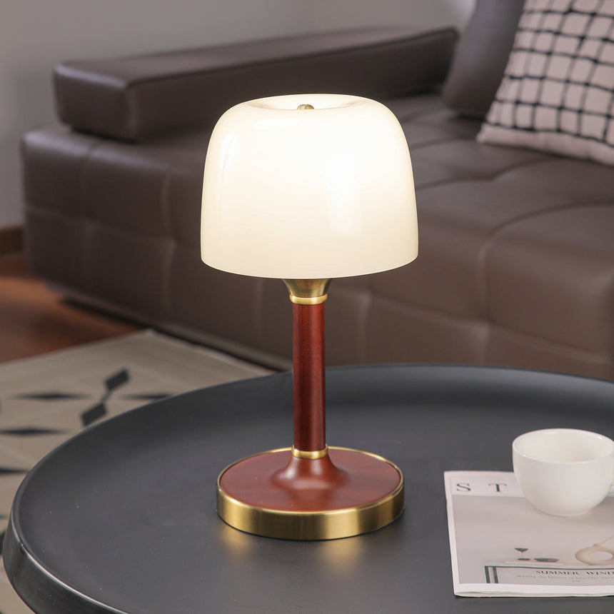 The white glass version lit softly on a round table by a sofa