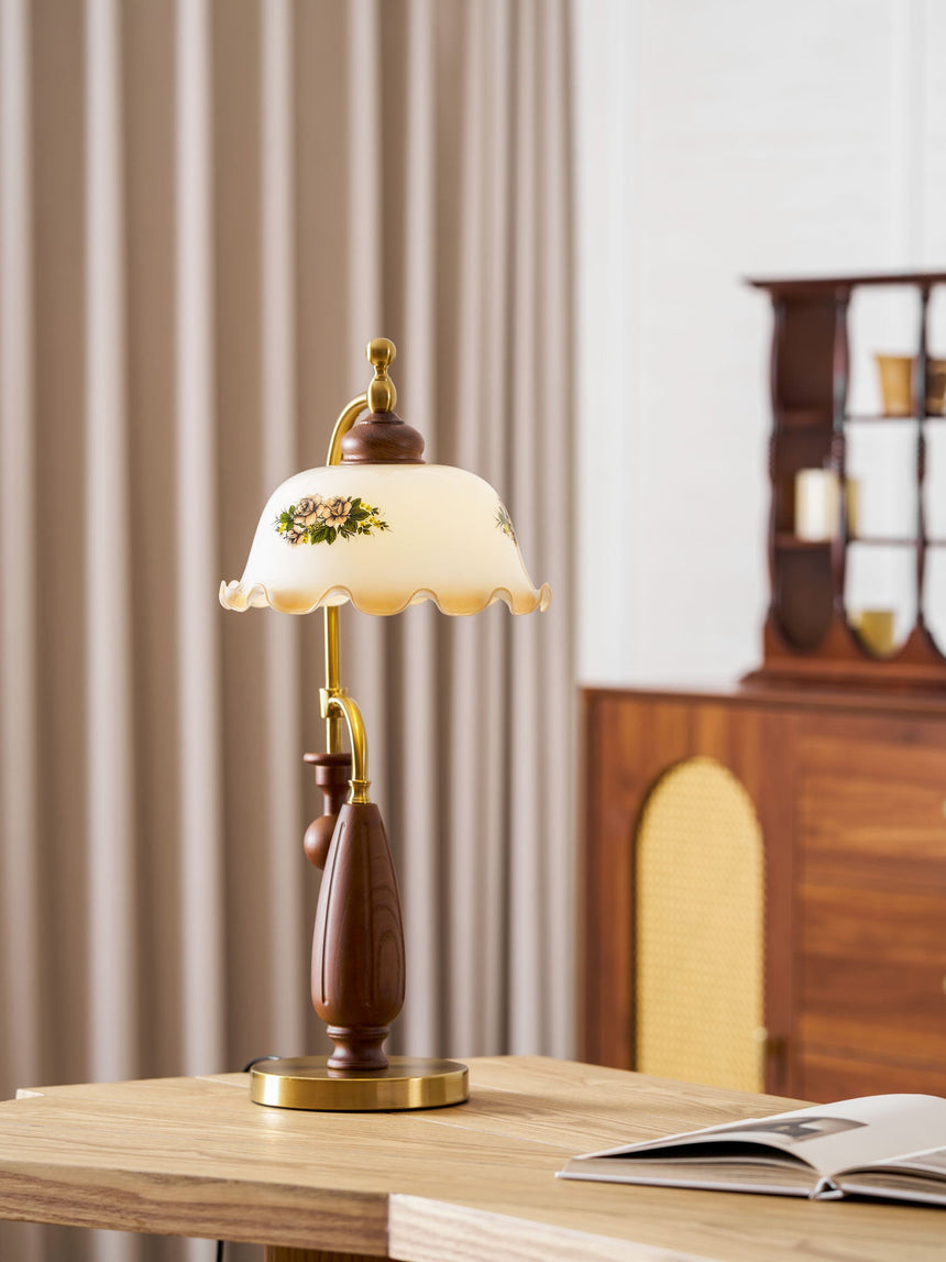Antique brass table lamp lit beside a glazed wood cabinet