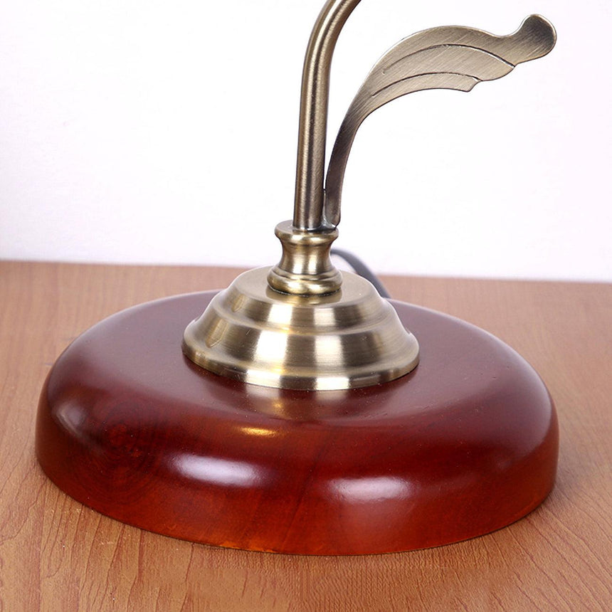 Close view of the round cherry wood base and the brass collar