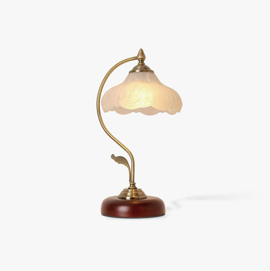 Frosted flower shade lamp seen from an angle, unlit, on a wood base