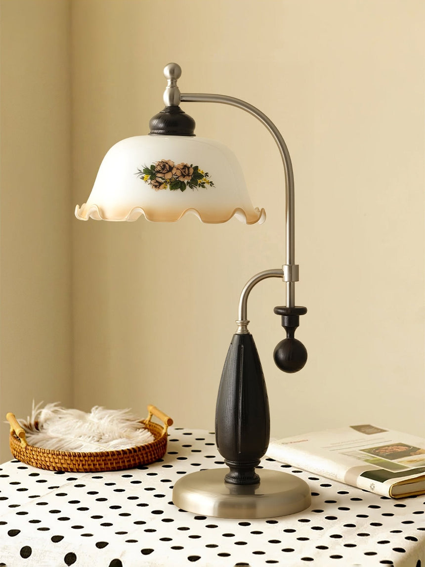 Antique brass table lamp lit on a table with a patterned cloth