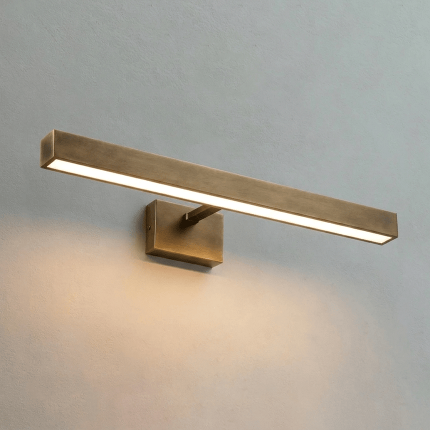 The brass bar lit at an angle, the strip visible along its lower edge