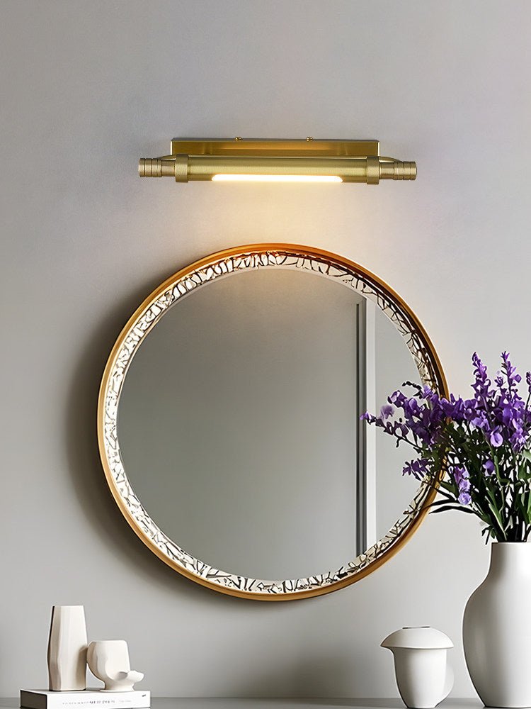 Brass tube above a beaded mirror with white vases on the counter below