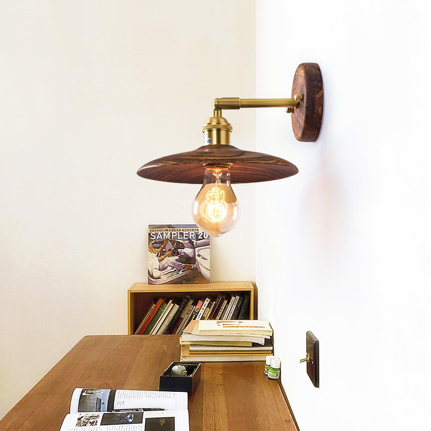 Sconce lit above a low bookcase stacked with books and magazines