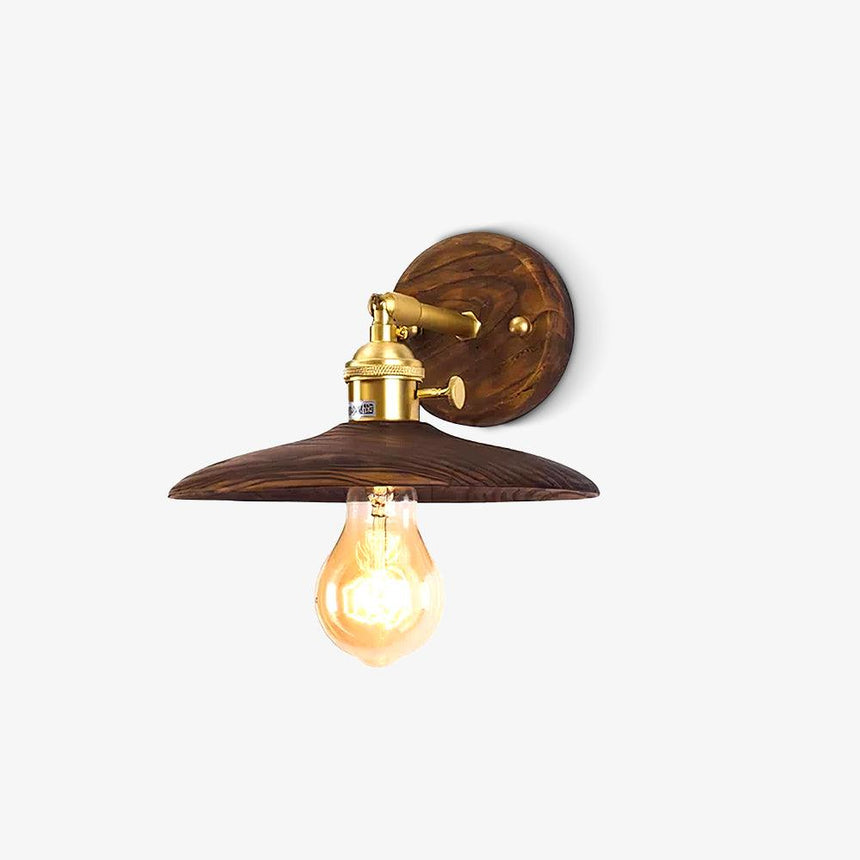 Brass wall sconce with a flared walnut shade against a plain ground