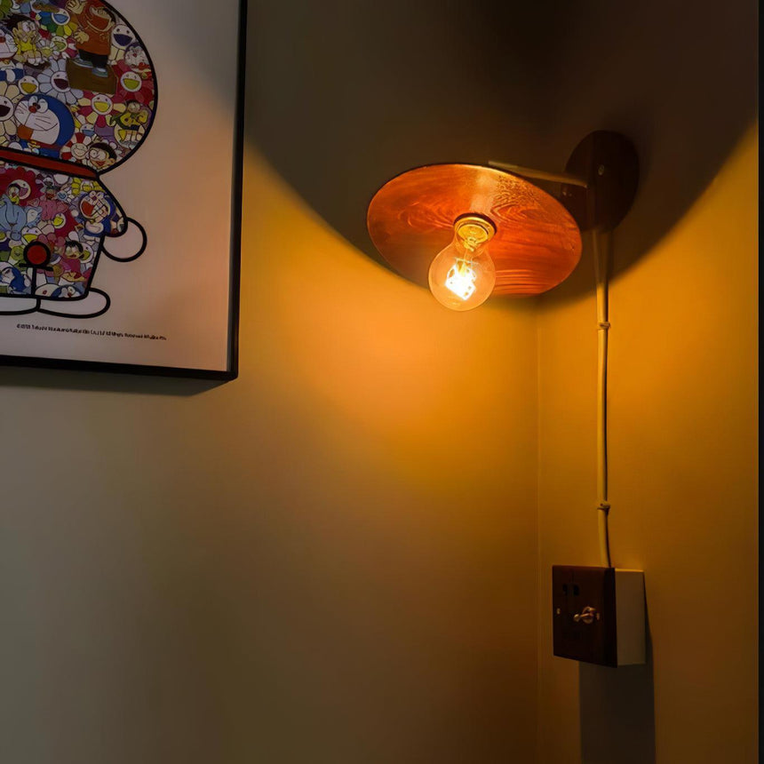 The sconce lit at night, warm light spilling down the wall below it
