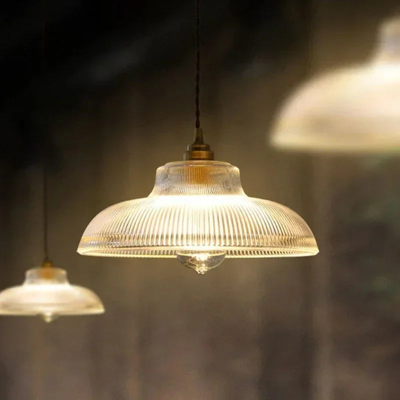 Amber prismatic shade lit under a dark painted ceiling in a dim room