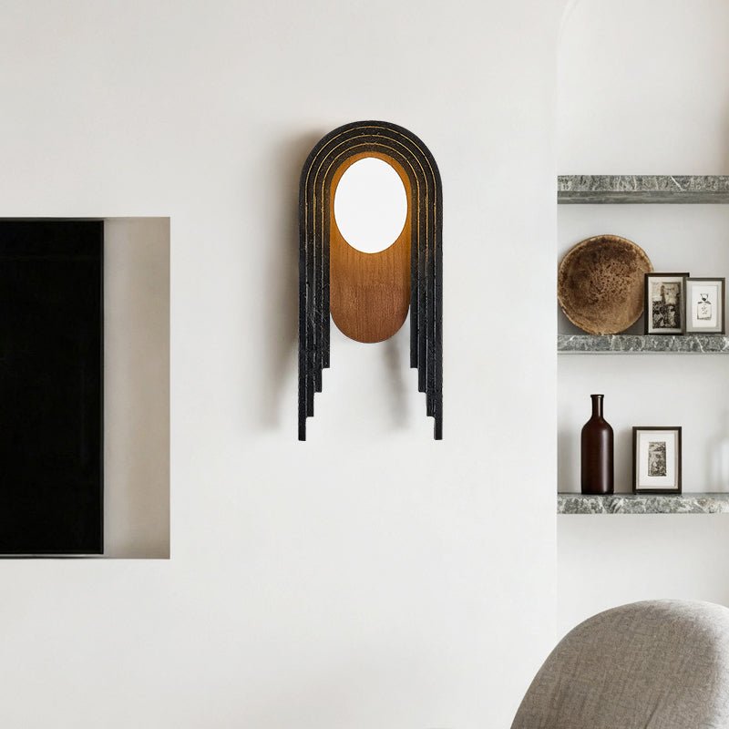 The arch lamp on a wall beside open shelves with a bowl and small frames