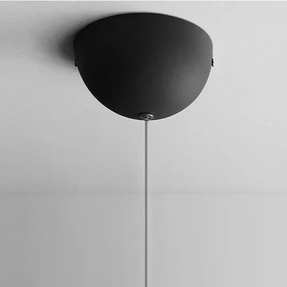 The black domed ceiling plate seen from below on a plain gray field