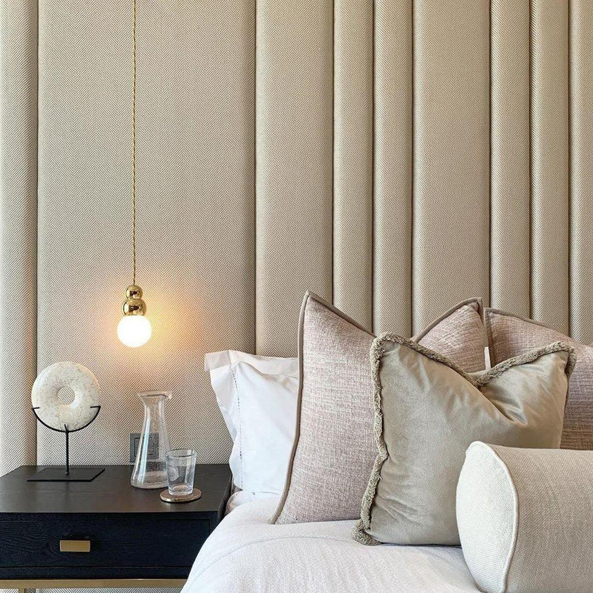 The ball light glowing beside a channel tufted headboard and pillows