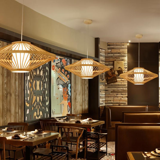 Four of the bamboo shades hung above a set restaurant table and chairs by a painted wall
