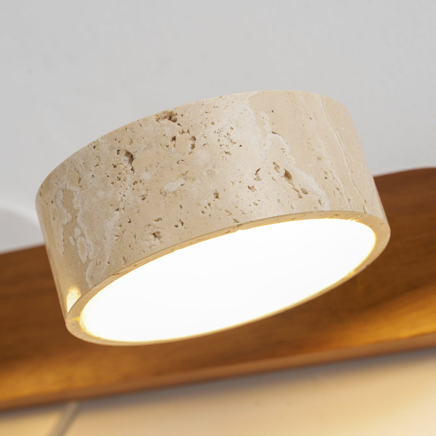 Lit travertine disc at the end of a wood bar, photographed close up