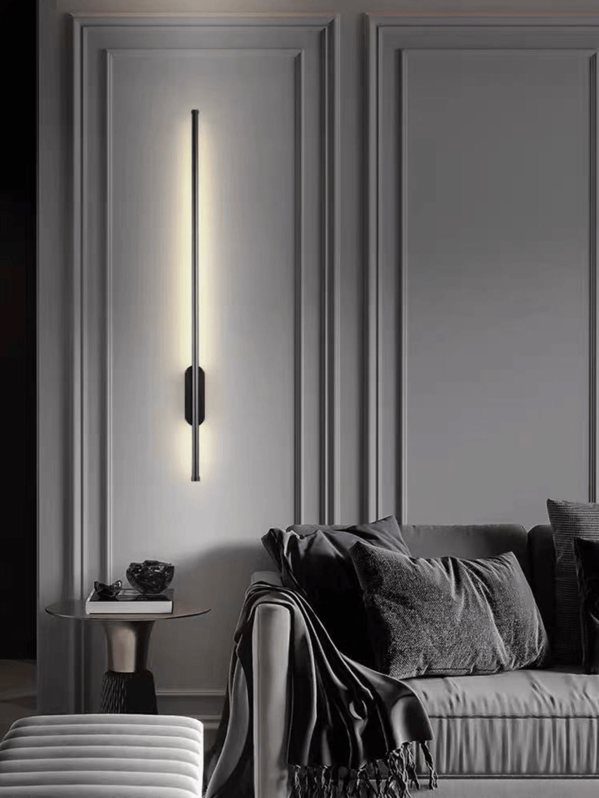 Lit on a paneled wall beside a chair with a throw and a small round table