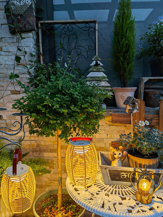 Several lit on a round garden table among pots and small ornaments