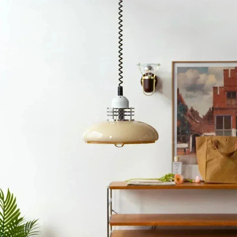 The saucer shade lit above a console beside framed artwork and a plant