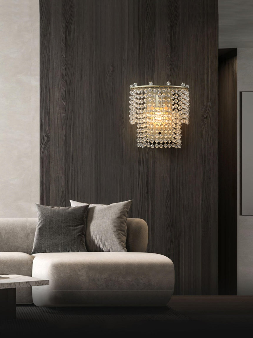 The beaded sconce on a dark wood wall above a white sofa