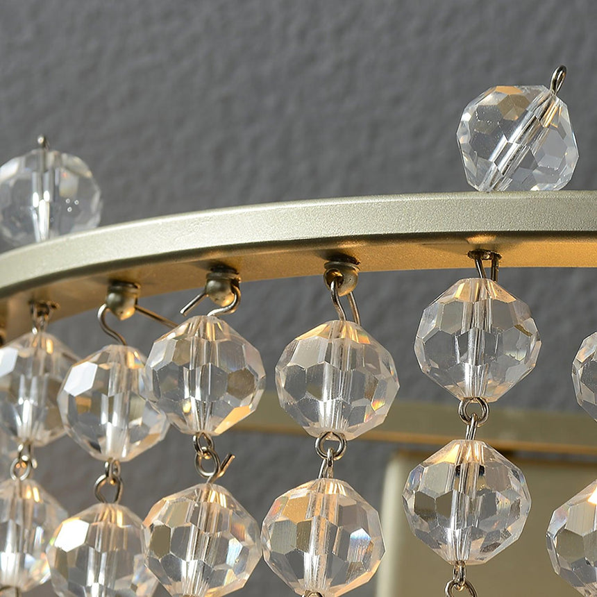 Close view of the gold ring and the faceted crystal beads hanging from it