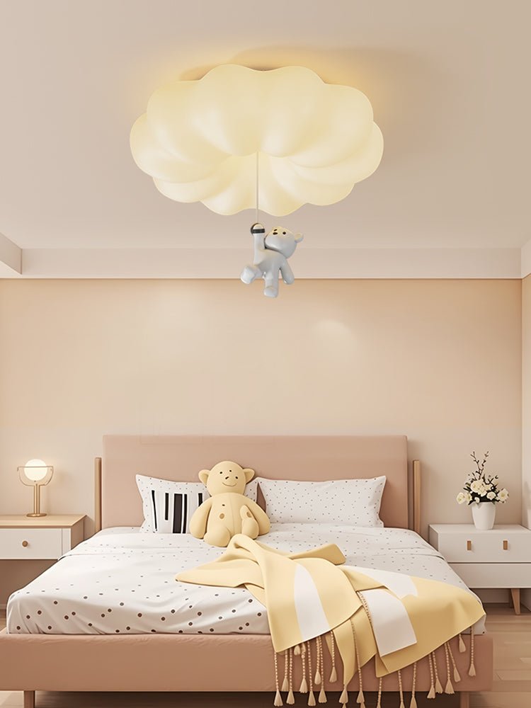 Cloud bear ceiling light in a child bedroom with a yellow throw and a pink bed