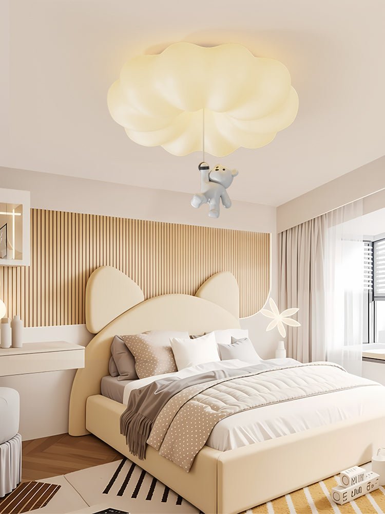 Cloud bear ceiling light above a bed with a bear ear headboard and a wood floor