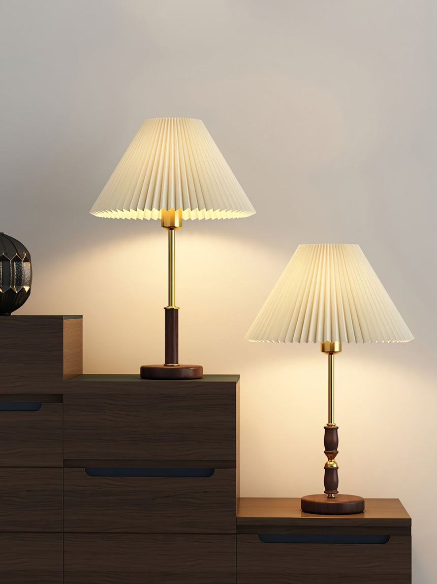 Two pleated shade bedside lamps lit on a stepped wooden unit