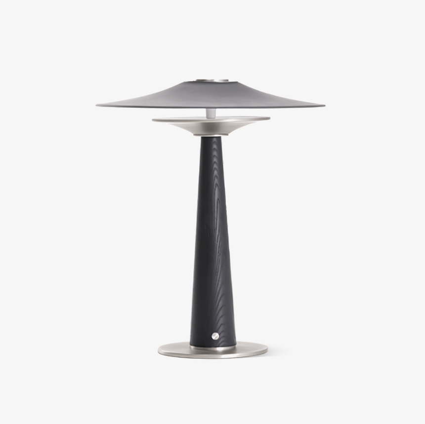 Bedroom table lamp with a wide disc on a black wood column, plain ground