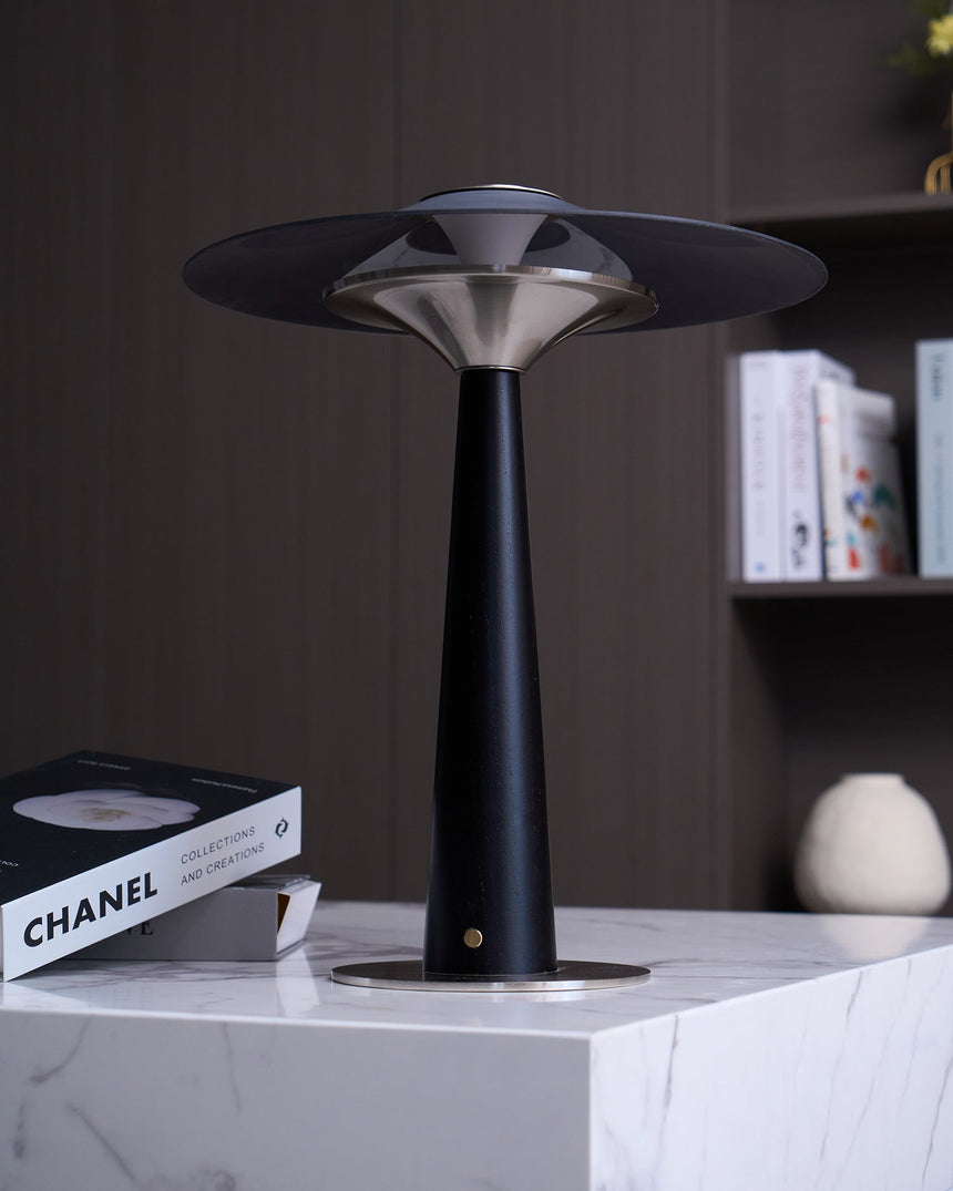 Bedroom table lamp on a marble plinth beside a book and a vase