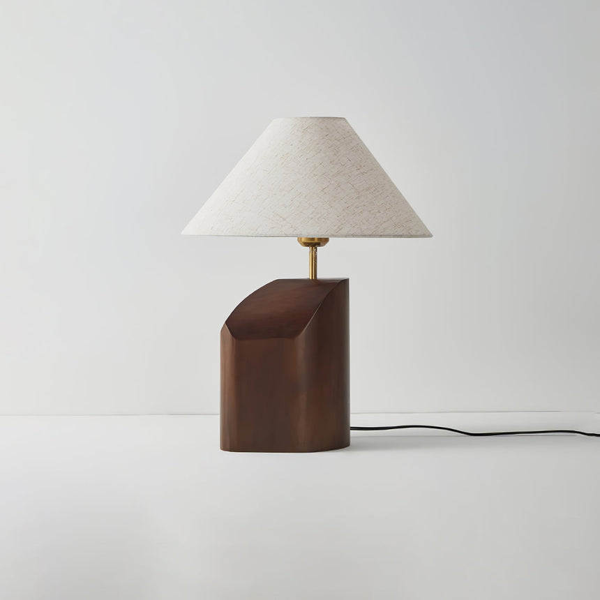 Bedroom table lamp unlit on a plain background, the curved base visible