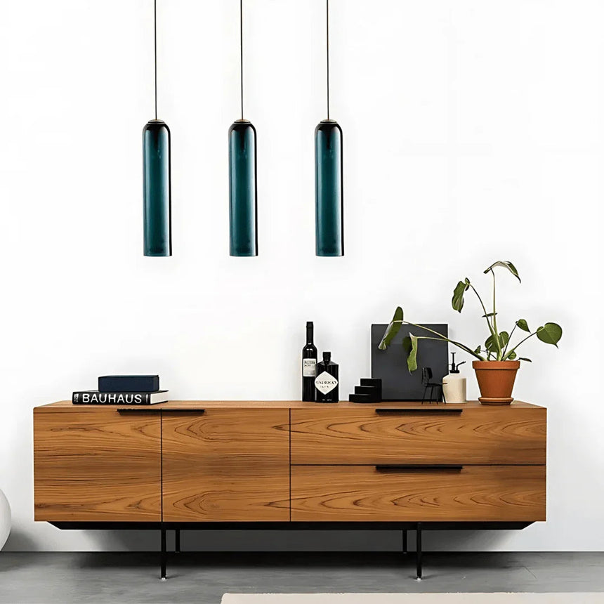 Three green tube pendants lit in a row above a wooden sideboard
