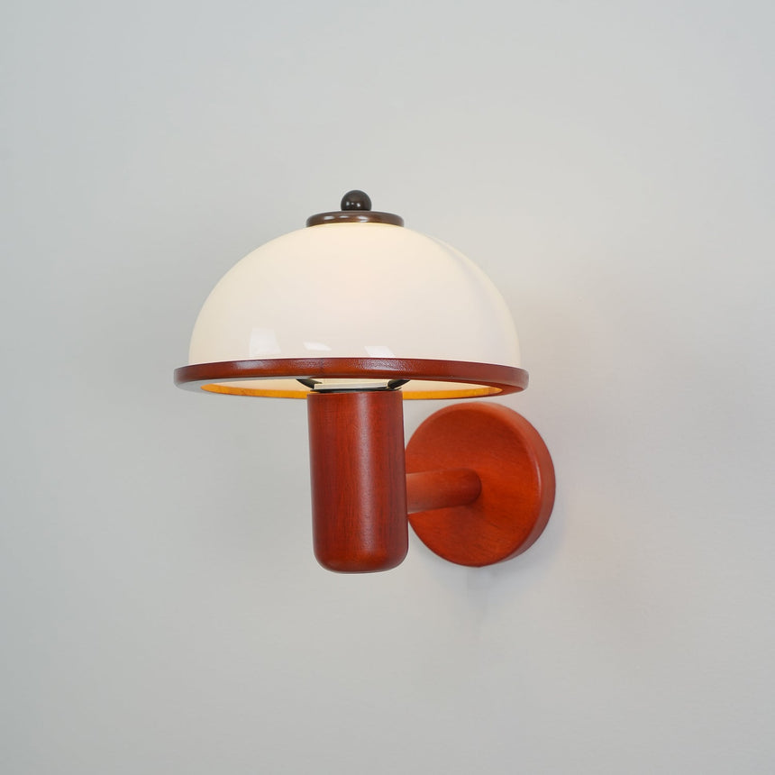 White dome shade on an oak arm seen straight on against a pale wall