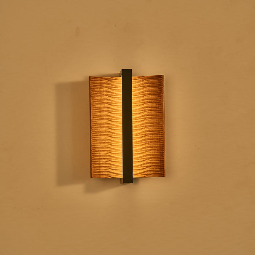 The fitting lit, warm light washing out from behind both curved wings