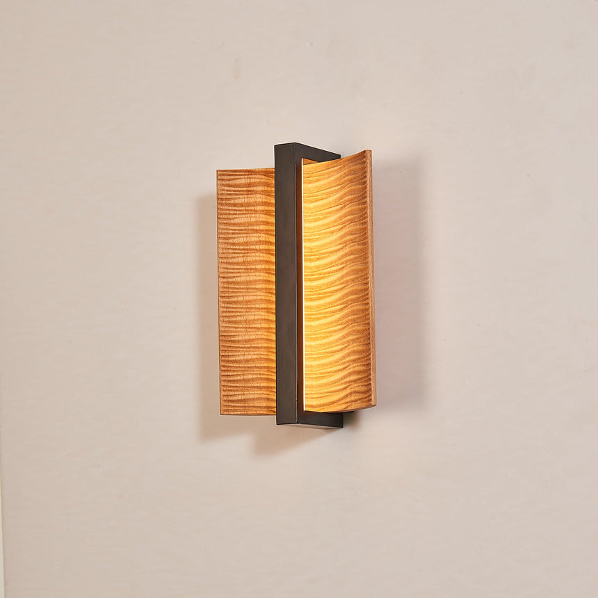 The fitting unlit, its own shadow falling across the wall behind it