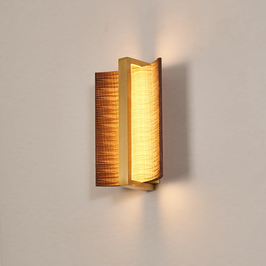 The fitting lit on a pale wall, warm light spilling above and below it