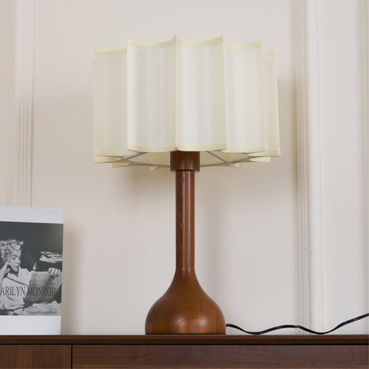 Close view of the lit scalloped shade and the turned oak stem