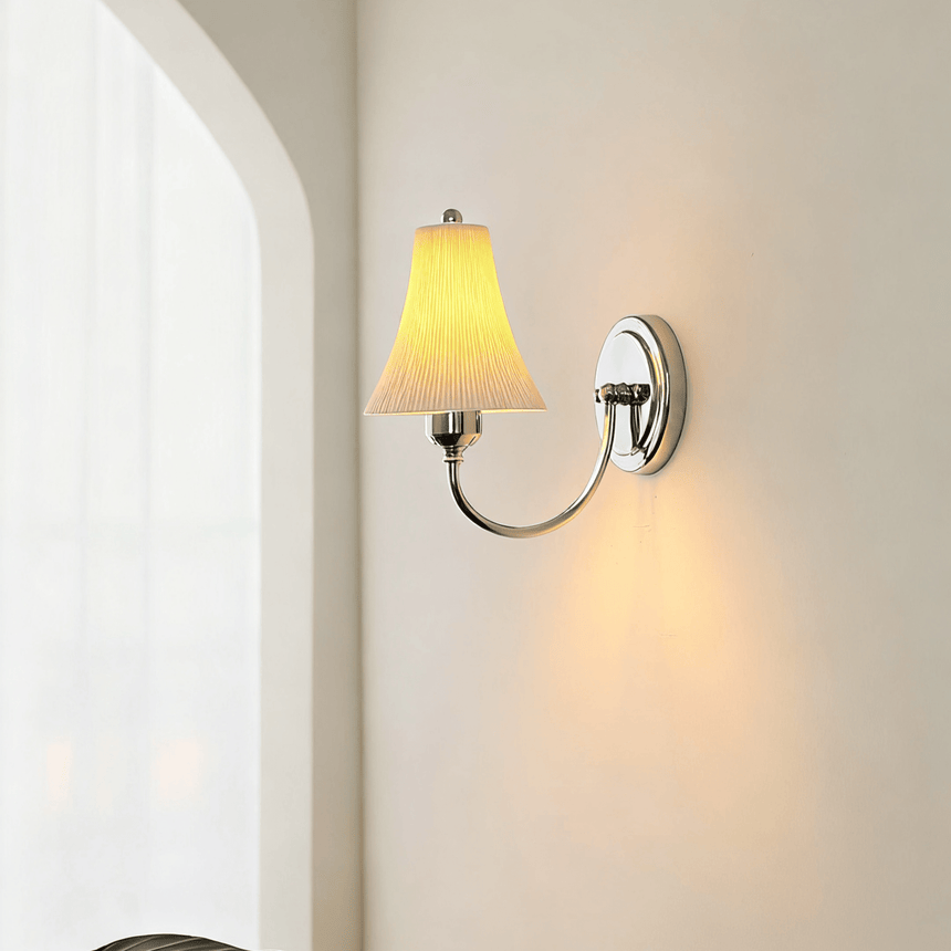 The sconce lit beside an arch, light washing the wall